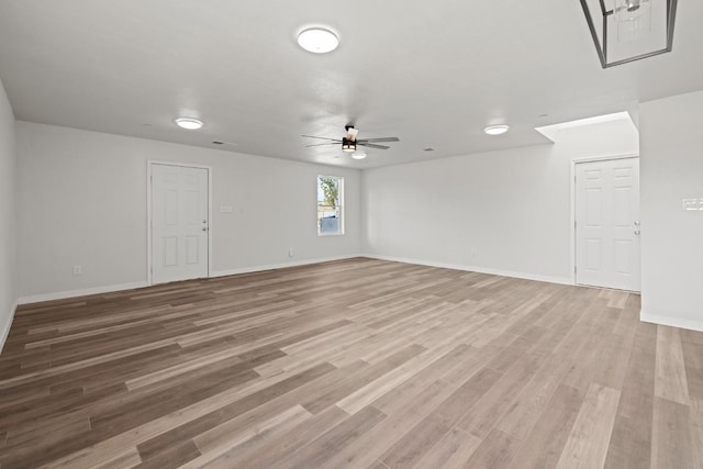 empty room with light wood-type flooring, ceiling fan, and baseboards