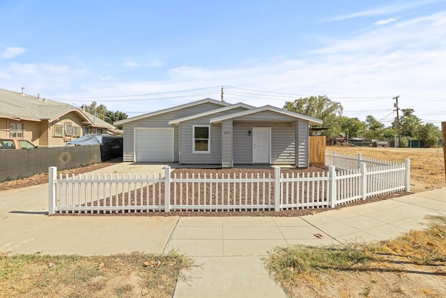 view of front of home featuring driveway, a fenced front yard, and an attached garage