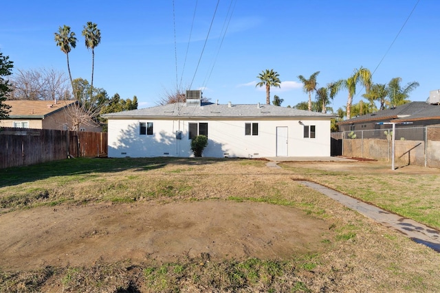 back of house featuring central AC unit and a yard