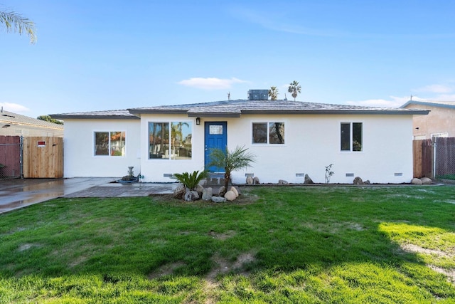 rear view of house featuring a lawn and a patio area