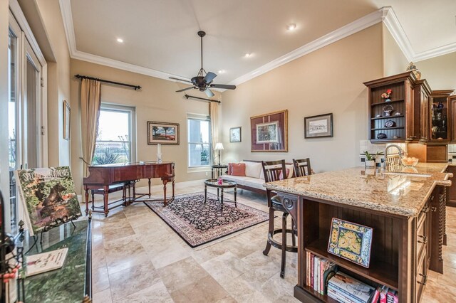 living room with ceiling fan, sink, and ornamental molding