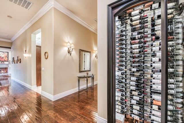 wine cellar featuring dark hardwood / wood-style floors, crown molding, and electric panel