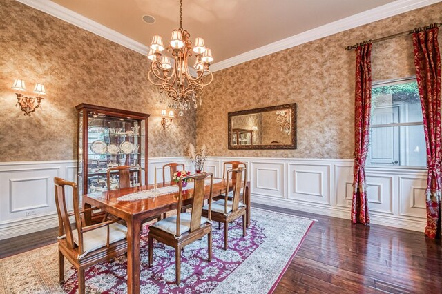 dining room featuring dark hardwood / wood-style floors, crown molding, and a chandelier