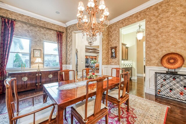 dining room with dark wood-type flooring, crown molding, and a chandelier