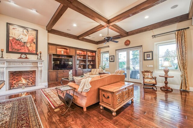 living room with ceiling fan, dark wood-type flooring, beam ceiling, and coffered ceiling