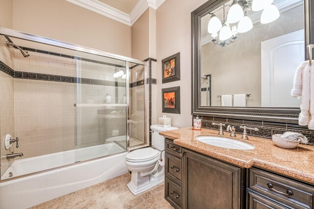 full bathroom featuring toilet, bath / shower combo with glass door, vanity, and ornamental molding