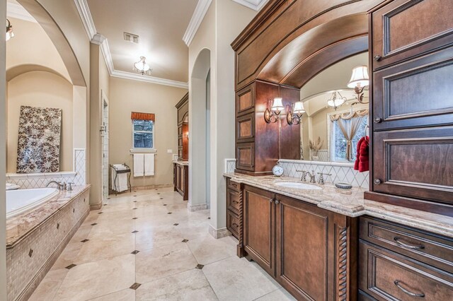 bathroom featuring lofted ceiling, vanity, ornamental molding, and tiled tub