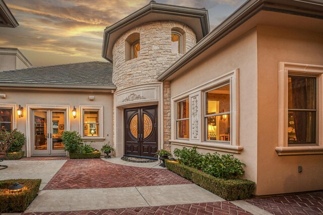 exterior entry at dusk featuring french doors