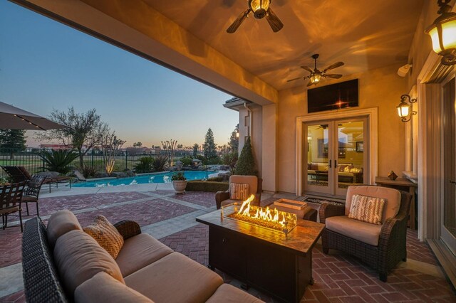 view of patio / terrace featuring french doors, an outdoor living space with a fire pit, and a fenced in pool