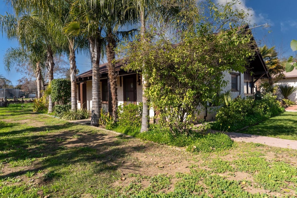 view of property hidden behind natural elements featuring a front lawn