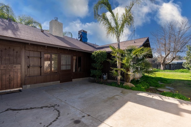 rear view of property featuring a yard and a patio