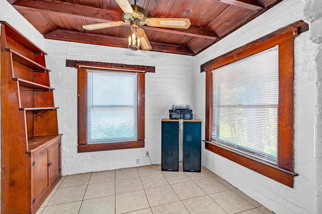 interior space featuring wooden ceiling, brick wall, lofted ceiling with beams, and ceiling fan