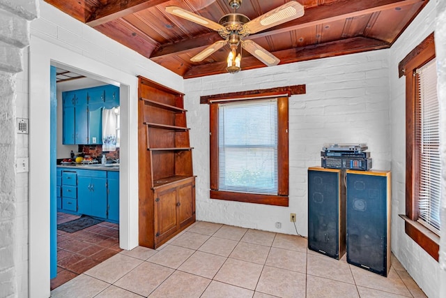 interior space with ceiling fan, wooden ceiling, light tile patterned floors, and vaulted ceiling with beams