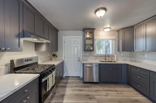 kitchen featuring light stone counters, sink, light hardwood / wood-style flooring, and stainless steel appliances