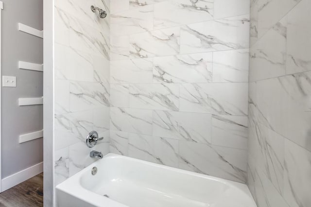 bathroom featuring tiled shower / bath combo and wood-type flooring