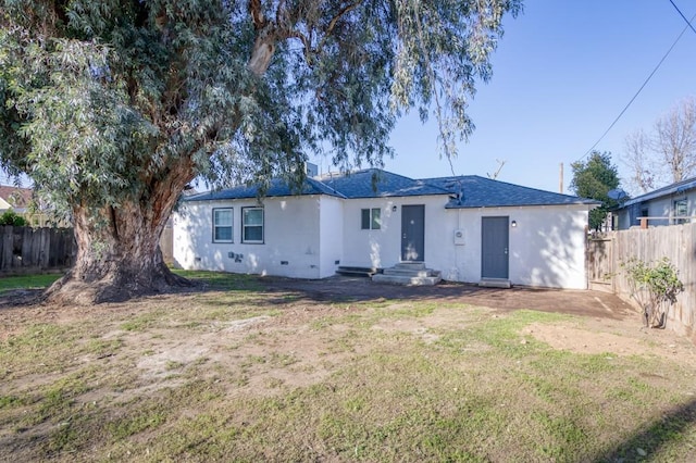 rear view of house featuring a lawn