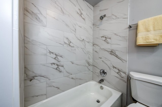 bathroom featuring toilet and tiled shower / bath combo