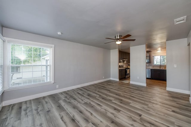 unfurnished living room featuring ceiling fan and light wood-type flooring