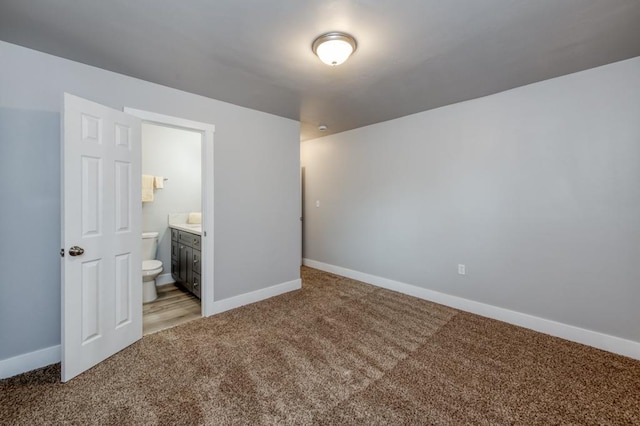 unfurnished bedroom featuring connected bathroom and light carpet