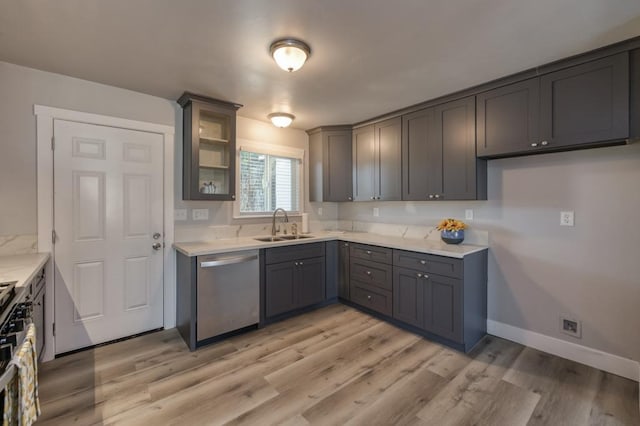 kitchen featuring light stone countertops, gray cabinetry, stainless steel appliances, sink, and light hardwood / wood-style flooring