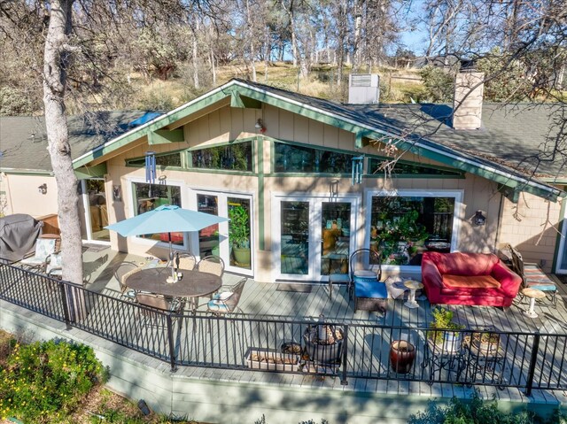 rear view of property featuring a wooden deck