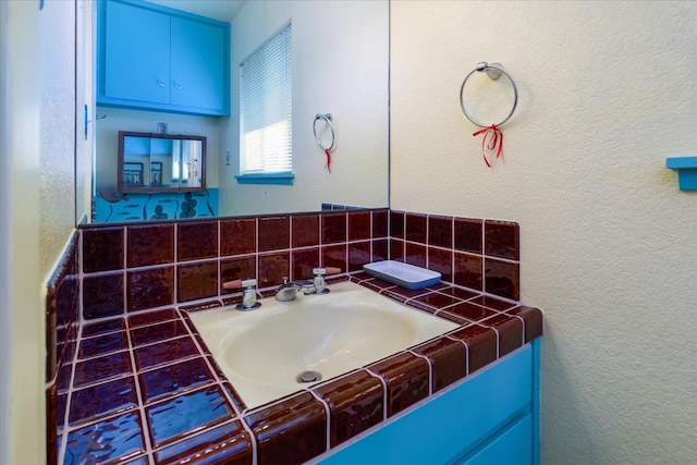 bathroom with vanity and tasteful backsplash