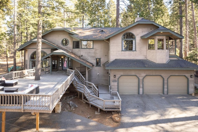 back of house featuring a deck and a garage