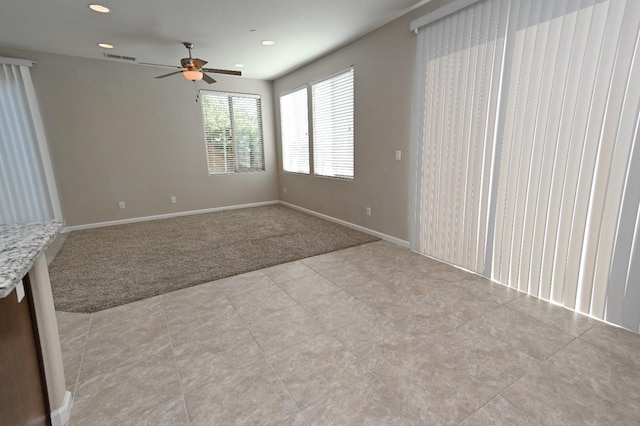 carpeted spare room featuring ceiling fan