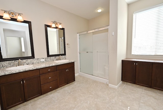 bathroom featuring a healthy amount of sunlight, vanity, and a shower with door