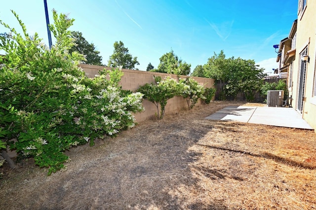 view of yard featuring central AC unit and a patio area