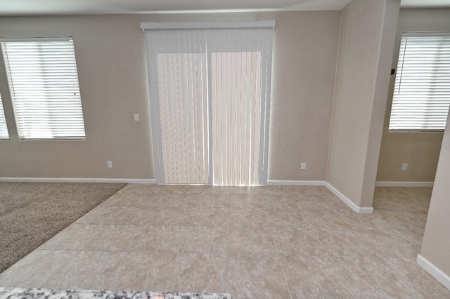 unfurnished room with light carpet and a wealth of natural light