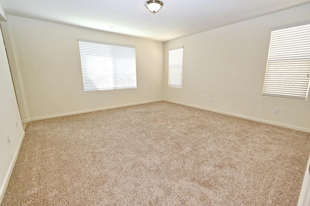 unfurnished room featuring light carpet