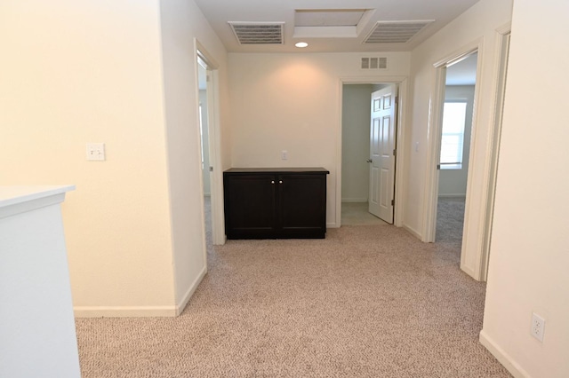 hall with light colored carpet