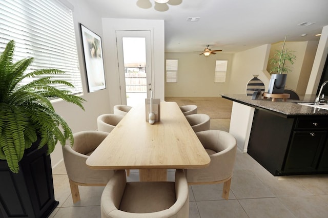 dining area with ceiling fan, light tile patterned flooring, and sink