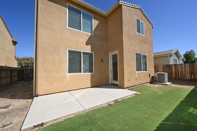 back of house with a patio area, central air condition unit, and a lawn