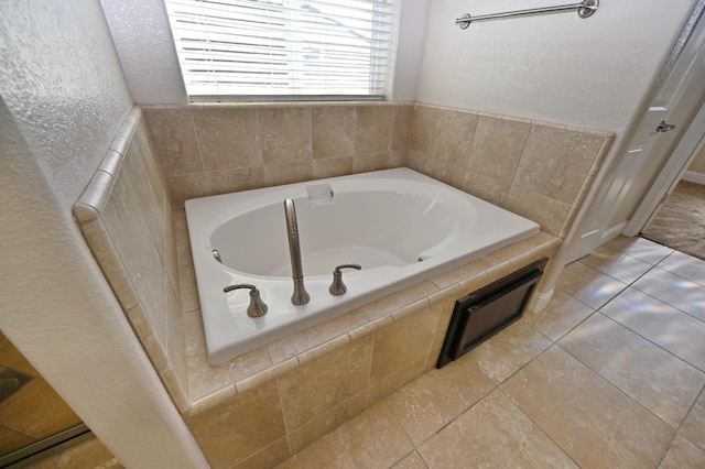 bathroom with a tub to relax in and tile patterned floors