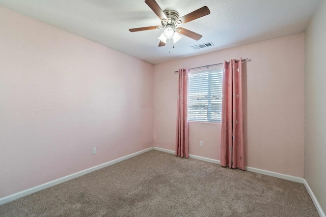 spare room featuring ceiling fan and carpet