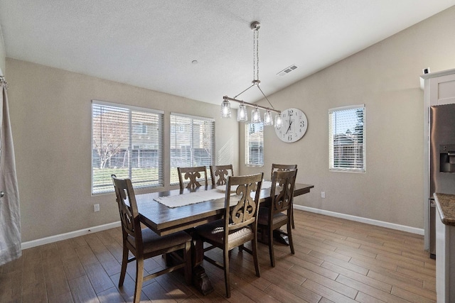 dining room with dark hardwood / wood-style flooring and lofted ceiling