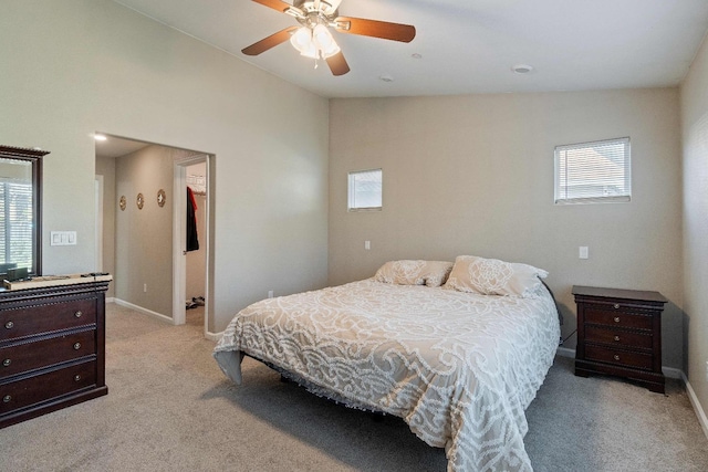 bedroom featuring ceiling fan, light carpet, multiple windows, and lofted ceiling