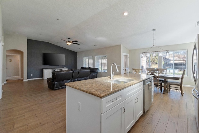 kitchen with white cabinets, dishwasher, sink, hanging light fixtures, and a kitchen island with sink