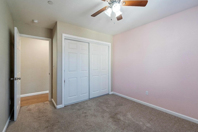 unfurnished bedroom with light carpet, ceiling fan, and a closet