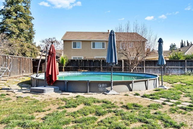 back of property featuring a fenced in pool and a yard