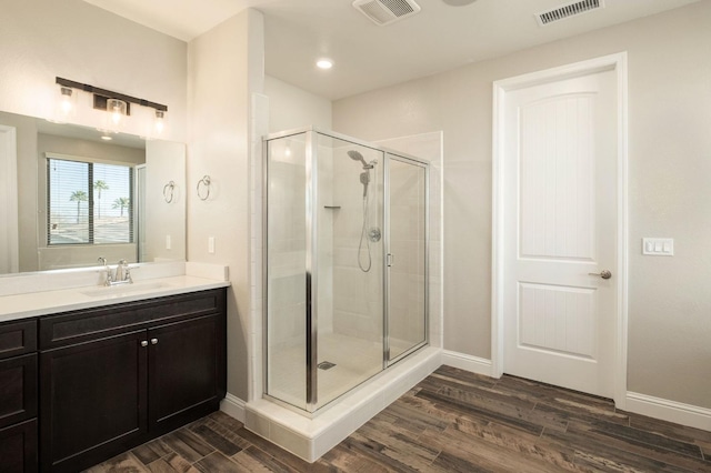 bathroom featuring a shower with shower door, vanity, and hardwood / wood-style flooring