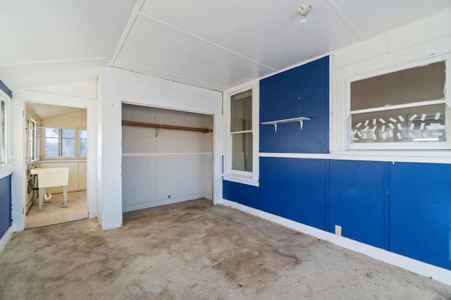 unfurnished bedroom featuring vaulted ceiling and carpet flooring