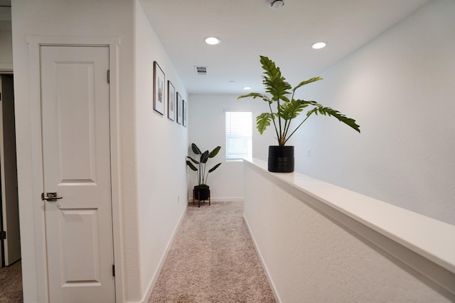 hallway featuring carpet, visible vents, baseboards, and recessed lighting