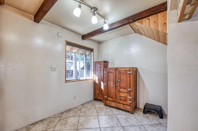 entrance foyer featuring light tile patterned floors, lofted ceiling with beams, and track lighting