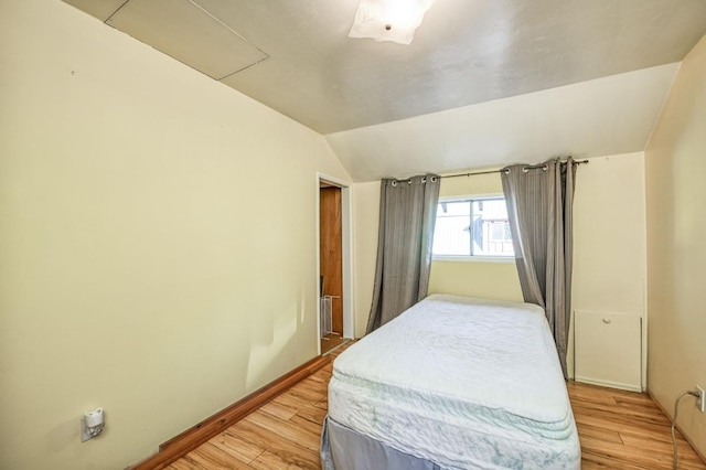 bedroom featuring light hardwood / wood-style floors and lofted ceiling