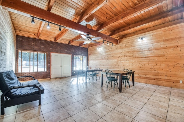 tiled dining space with ceiling fan, wood ceiling, wood walls, and track lighting