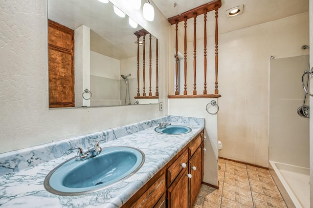 bathroom featuring toilet, a shower, and vanity