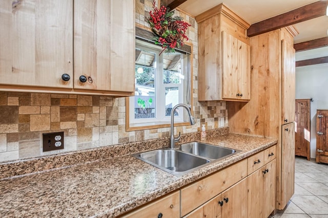 kitchen featuring light brown cabinetry, light tile patterned floors, sink, and beamed ceiling